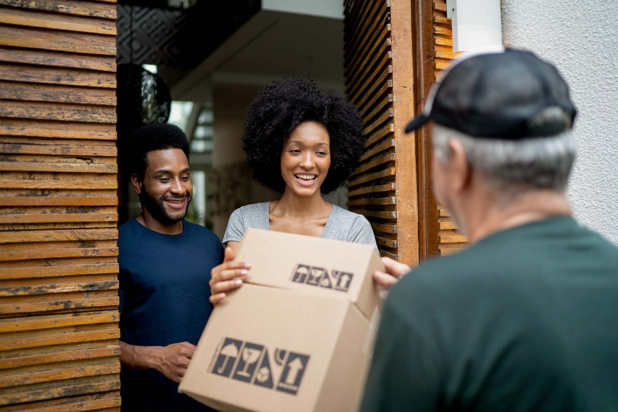Young couple receiving package from delivery man